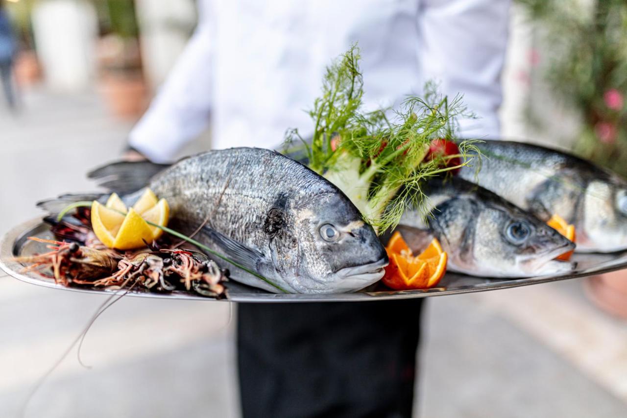 Lighthouse Golf & Spa Hotel Balchik Exterior foto A waiter holding a platter of fish